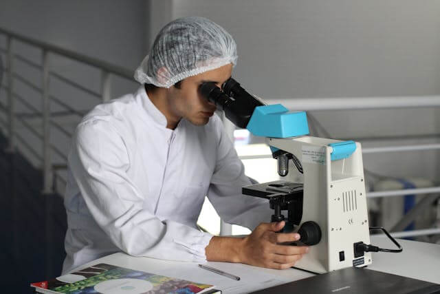 Image of a man looking through a microscope 