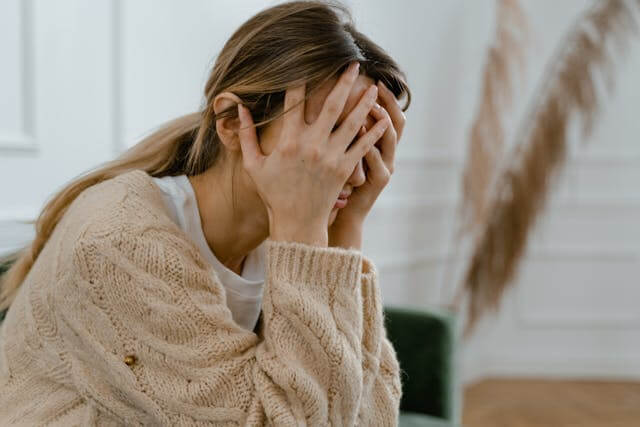 Image of A stressed woman holding her head