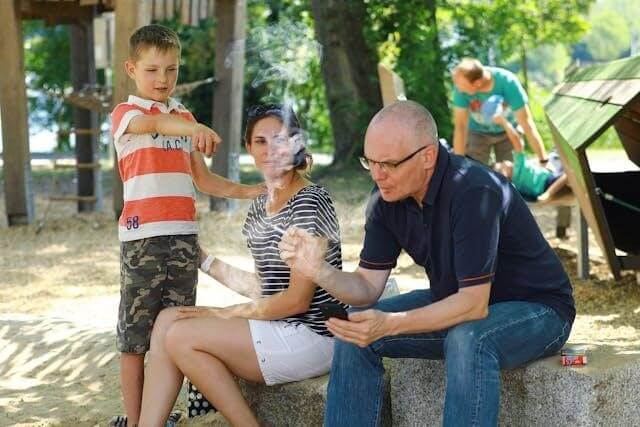 Image of A man smoking a cigarette while his son is pointing at him